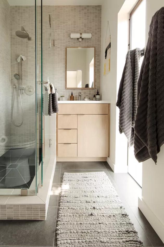 Идея маленькой ванной комнаты с мозаичной плиткой на стене и деревянным туалетным столиком